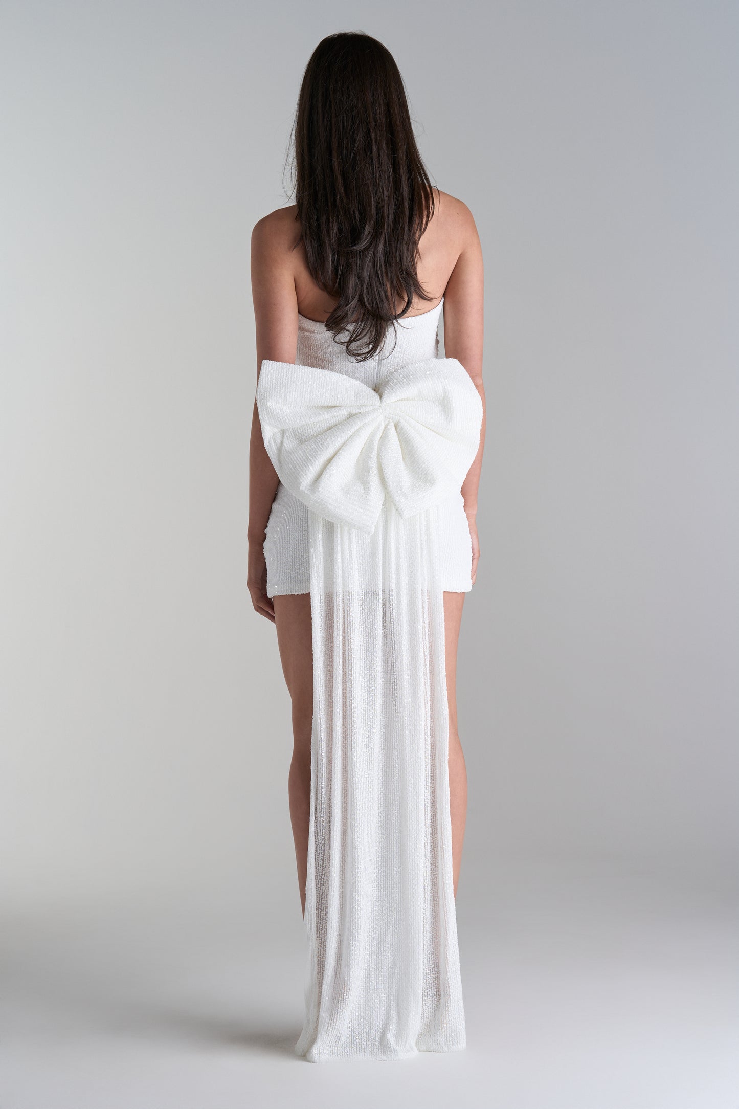 Model wearing mini dress with big bow