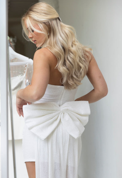 Model wearing mini dress with big bow