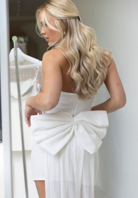 Model wearing mini dress with big bow